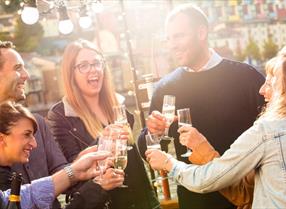 A group of people have drinks on a Bristol Packet Boat