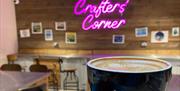 Crafter's Corner neon sign, coffee in front