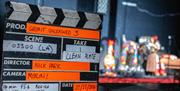 A clapper board infront of the statues