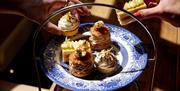 Hands reaching for cakes in afternoon tea