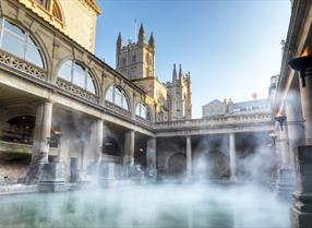 Steam rises from The Roman Baths